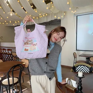 Detailed view of the quilted tote bag with cute bear embroidery in a cozy cafe setting scene.