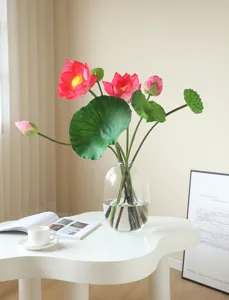 Artificial lotus flower arrangement in glass vase for home decor and photography props.