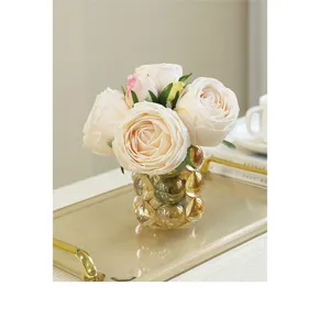 Artificial rose bouquet detail showing realistic texture and elegant bubble glass vase decor.