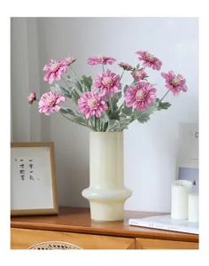 Detailed view of artificial pink cosmos flowers in ceramic vase for home tabletop decor.