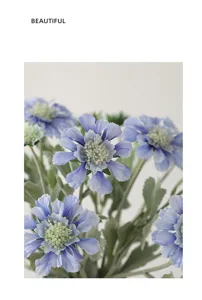 Detail view of artificial cosmos flower bouquet, vivid blue petals with realistic green leaves.