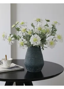 Artificial cosmos flower bouquet in dark blue textured vase for home decor table detail.