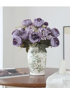 Gros plan détaillé d'un arrangement de fleurs de pivoine mauve artificielles dans un vase en céramique.