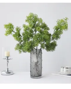 Artificial 3-prong fuzzy grass green plant with grey textured glass vase for home decor.