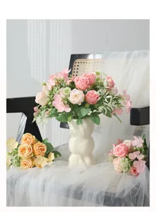 Joli bouquet de roses artificielles en soie avec vase céramique pour décoration de table.