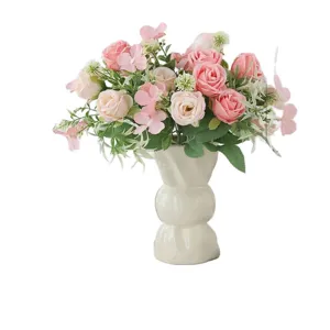 Bouquet de roses artificielles avec vase en céramique blanche pour décoration.