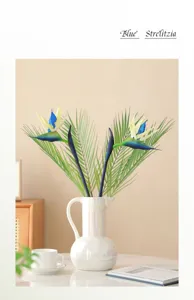 Detailed view of artificial Strelitzia bird of paradise flowers in elegant ceramic vase, home decor.