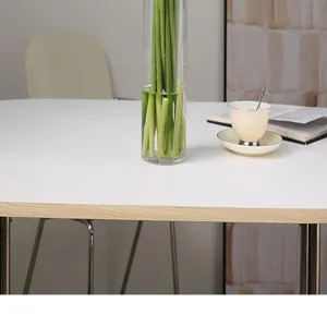 Gedetailleerd overzicht van kunstmatige calla-stengels in glazen vaas op witte tafel.