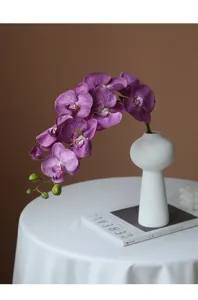 Detailed shot of artificial phalaenopsis orchid flower in a vase for home table decor.