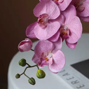 Artificial pink orchid flower branch, realistic texture fake floral home decor centerpiece.