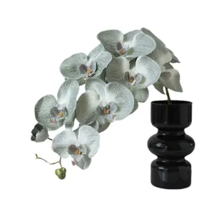 Artificial Phalaenopsis orchid flower arrangement with black vase for home decor.