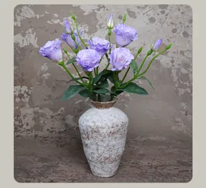Artificial purple lisianthus flower bouquet with vintage ceramic vase detail shot.