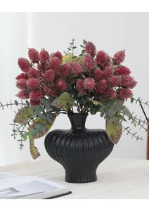 Artificial banksia flower bouquet with black ceramic vase for home decor and retro photography.