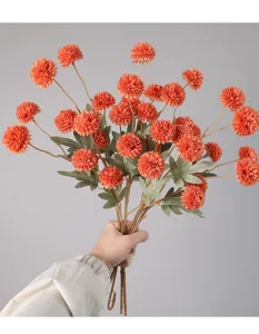 Primo piano dettagliato di un bouquet di crisantemi pompon arancioni artificiali, decoro.
