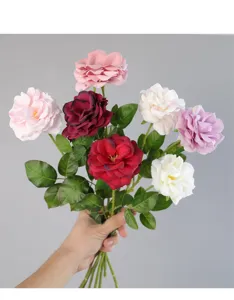 Vista dettagliata del bouquet di rose artificiali colorate con foglie verdi realistiche.
