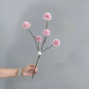 Detailed view of artificial pink pom-pom chrysanthemum flower branch for home decor.