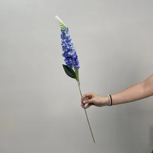 Vue détaillée d'une seule tige de fleur de delphinium artificielle aux fleurs bleues.