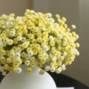 Artificial yellow baby's breath flowers in a white vase, perfect for home and wedding decor.