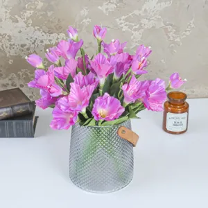 Artificial gladiolus flowers in textured glass vase with leather strap handle home decor.