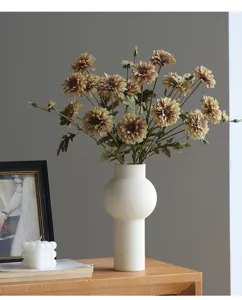 Detailansicht pastoraler künstlicher Chrysanthemenblüten in weißer gerippter Keramikvase als Deko.