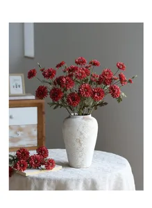 Detailansicht künstlicher roter Chrysanthemen in einer eleganten Vase für Raumdekoration.
