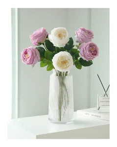 Vista dettagliata di un bouquet di rose artificiali Austin in vaso di vetro scanalato.