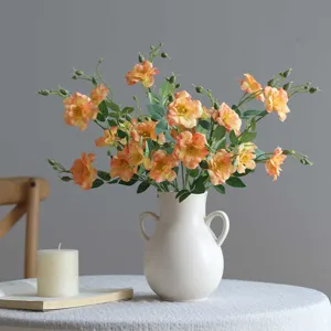 Artificial small rose flower bouquet with ceramic vase for home decor desk setup.