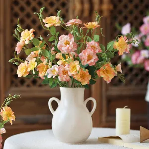 Artificial mini rose flower bouquet in white ceramic vase, elegant home decor for living room.