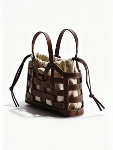 Bruine lederen gevlochten cutout tote tas met canvas drawstring binnenzak detail.