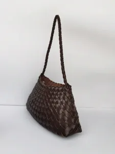 Dettaglio della borsa in pelle intrecciata, borsa a mano marrone scuro, elegante tracolla.