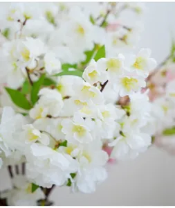 Detailopname van kunstmatige witte kersenbloesemtak, realistisch zijden bloemdecor voor thuis.