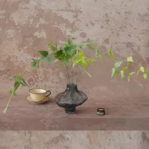 Artificial clematis vine green plant in smoky grey glass vase home decor aesthetic table setup