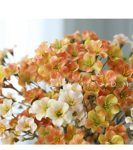 Detailed view of rustic artificial plum flower bouquet, orange and white gradient, home decor.