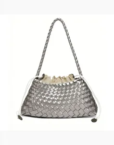 Close-up view of the metallic silver woven leather handbag, highlighting intricate strap texture.