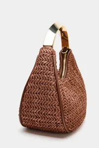 Brown woven dumpling handbag detail showcasing unique metallic handle and leather trim design.