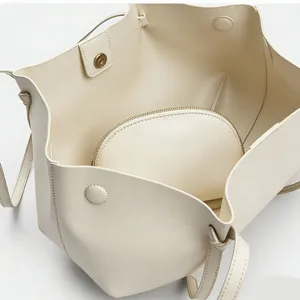 Beige Leder Tragetasche Detail Innenansicht mit geräumigem Fach und passender Reißverschlusstasche.
