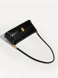 Detailed view of the sleek black leather underarm shoulder bag with elegant gold hardware.