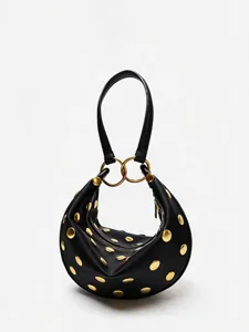 Détail de la sacoche épaule noire en forme de croissant avec des rivets métalliques dorés.