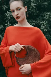 Chic woven dumpling bag detail, elegant metal handle, unique design, premium textured handbag.