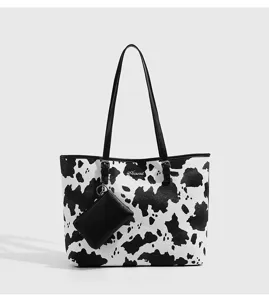 Detailansicht der stilvollen schwarz-weißen Kuh-Print-Tasche mit kleiner Tasche.