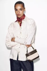 Detalle de neceser de lona en bloque de color, bolso de mano elegante para mujer, accesorio chic.