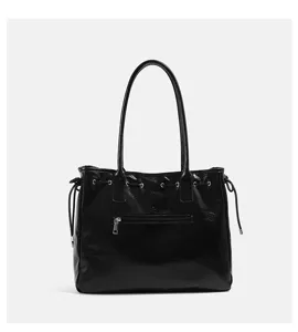 Nahaufnahme der schwarzen glänzenden Damen Schultertasche mit Vordertasche und Kordelzug.