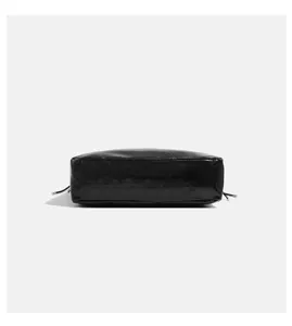 Detailansicht einer schwarzen Schulter-Tragetasche aus Knautschleder im minimalistischen Retro-Stil.