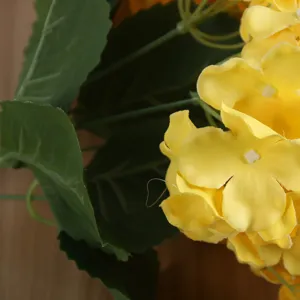 Primo piano dettaglio dei petali di ortensia gialla artificiale e trama delle foglie.