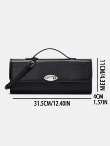 Zwarte baguette tas van hagedis patroon leer met metalen slot en handvat detail.