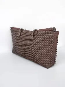 Primer plano del bolso tote de cuero tejido marrón oscuro que muestra textura y gran capacidad.