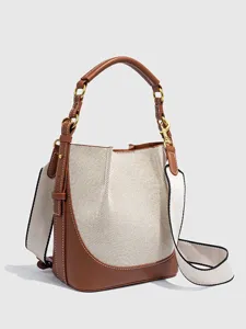 Detailansicht der stilvollen Kanvas-EimerTasche mit braunem Lederbesatz und breitem Gurt.