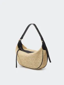 Detailed view of straw hobo shoulder bag, featuring black leather trim, zipper and strap.