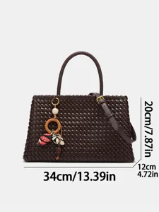 Dark brown woven leather tote bag with shoulder strap and chic charm, stylish and practical.