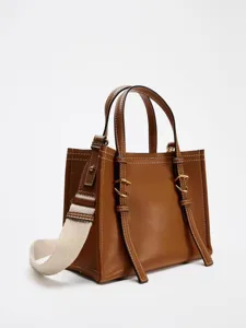 Mini sac marron avec bandoulière en toile et coutures contrastées pour le travail quotidien.